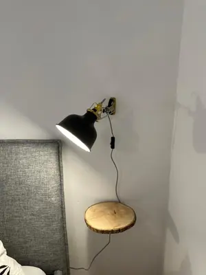 a lamp hanging on a wall next to a chair at Dolomites Smart Holidays in Valdaora