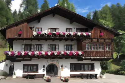 a building with flowers on the front of it at Hotel Al Larin in Cortina dʼAmpezzo