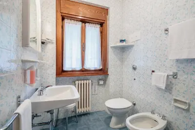 a bathroom with a sink toilet and a window at Hotel Al Larin in Cortina dʼAmpezzo
