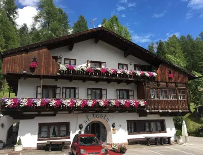 a building with flowers on the side of it at Hotel Al Larin in Cortina dʼAmpezzo