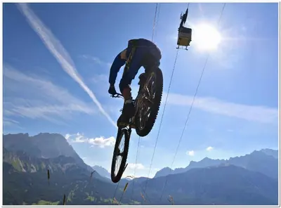 a man doing a trick on a bike in the air at Hotel Al Larin in Cortina dʼAmpezzo
