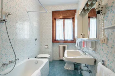 a bathroom with a tub and a sink and a toilet at Hotel Al Larin in Cortina dʼAmpezzo