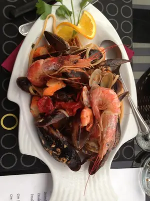 a plate of food with shrimp and mussels on a table at Albergo Casagrande in Laives