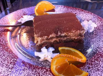 a piece of chocolate cake on a plate with orange slices at Albergo Casagrande in Laives