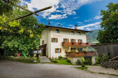 a white house with a balcony and a fence at Mareinhof - Urlaub auf dem Apfelbauernhof in Parcines