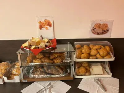 three trays of bread and pastries on a table at Hotel Fiera in Bolzano