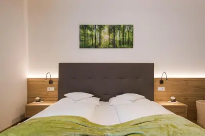 a bedroom with a large bed with a painting on the wall at Grieserhof Algund in Lagundo