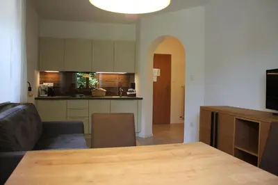 a living room with a table and a kitchen at Grieserhof Algund in Lagundo