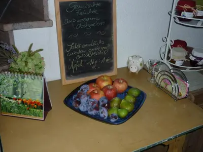 a plate of fruit on a table with a chalkboard at Grieserhof Algund in Lagundo