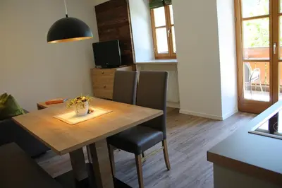 a dining room with a wooden table and chairs at Grieserhof Algund in Lagundo