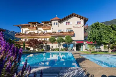 a hotel with a swimming pool in front of a building at Hotel Untermelz in Plaus