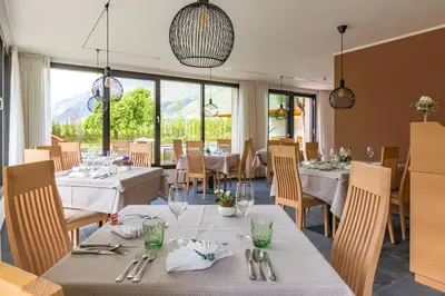 a restaurant with white tables and chairs and windows at Hotel Untermelz in Plaus