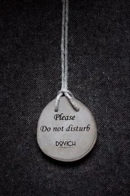 a small white ornament with a message do not disturb at Hotel & Ristorante Baita Dovich in Malga Ciapela