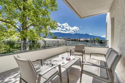 a patio with a table and chairs on a balcony at Das Mitterplarser Hotel in Lagundo