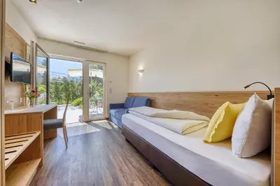 a bedroom with a large bed and a large window at Das Mitterplarser Hotel in Lagundo