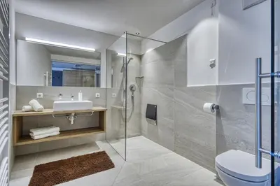 a bathroom with a shower and a toilet and a sink at Das Mitterplarser Hotel in Lagundo