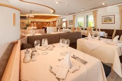 a dining room with white tables and chairs at Das Mitterplarser Hotel in Lagundo