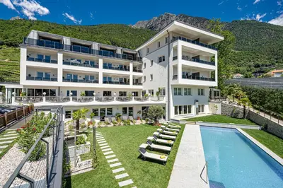 an exterior view of a hotel with a swimming pool at Das Mitterplarser Hotel in Lagundo