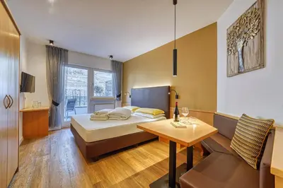 a bedroom with a bed and a table and a couch at Das Mitterplarser Hotel in Lagundo