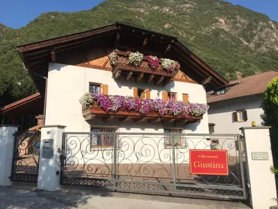 a building with a balcony with flowers on it at Appartamento Giustina in Gargazzone
