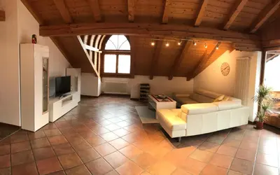 a large living room with a couch and a tv at Appartamento Giustina in Gargazzone