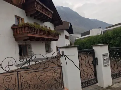 a white building with a gate and a balcony at Appartamento Giustina in Gargazzone