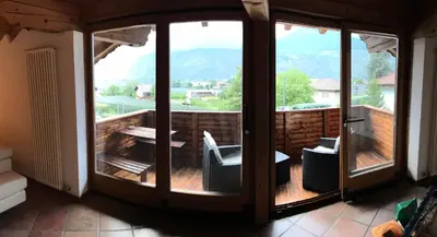 a room with a balcony with a table and chairs at Appartamento Giustina in Gargazzone