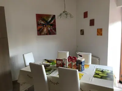 a dining room table with chairs and a table with food on it at Appartamento Giustina in Gargazzone