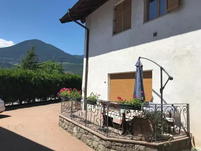 a balcony with flowers and an umbrella on a building at Appartamento Giustina in Gargazzone