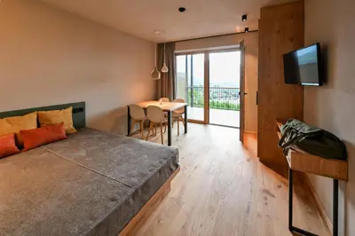 a bedroom with a bed and a dining room with a table at Residence Winklgut in Lagundo