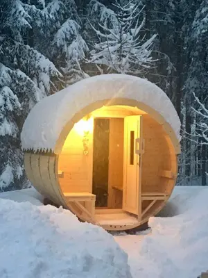 a sauna in the snow with the lights on at Hotel Garnì Il Cirmolo in Rocca Pietore