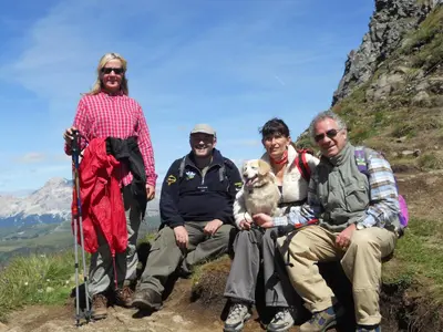a group of people sitting on the side of a mountain at Hotel Garnì Il Cirmolo in Rocca Pietore