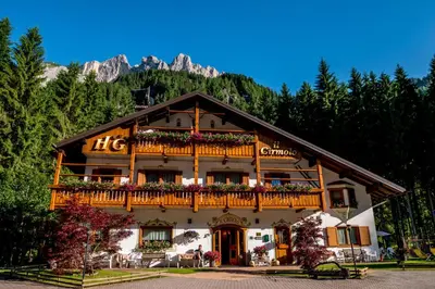 a large building with a balcony on a mountain at Hotel Garnì Il Cirmolo in Rocca Pietore