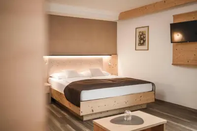 a bedroom with a bed and a table in it at Hotel Karin in Tirolo