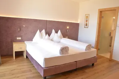 a bedroom with a large bed with two white pillows at Hotel Karin in Tirolo