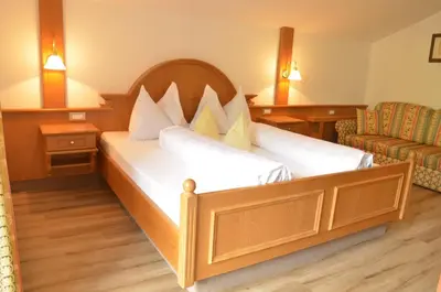 a hotel room with a bed and a chair at Hotel Karin in Tirolo