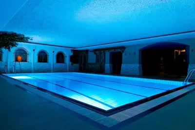 a swimming pool with blue lighting in a house at Hotel Arnika Wellness in Passo San Pellegrino