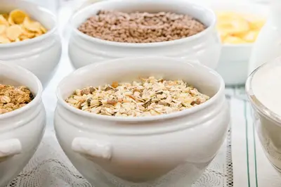 a group of white bowls filled with granola at Hotel Arnika Wellness in Passo San Pellegrino