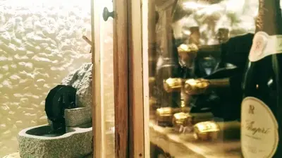 a window with a bunch of bottles of wine at Hotel Arnika Wellness in Passo San Pellegrino
