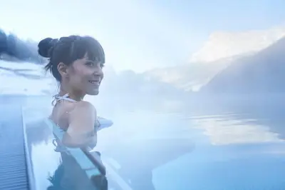 a woman standing in a body of water at Hotel Cristallo - Wellness Mountain Living in La Villa