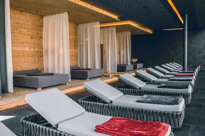 a row of couches and chairs in a room at Hotel Cristallo - Wellness Mountain Living in La Villa