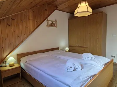a bedroom with a bed with towels on it at La Casa del Mulino in Pozza di Fassa