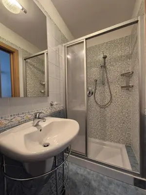 a bathroom with a sink and a shower at La Casa del Mulino in Pozza di Fassa