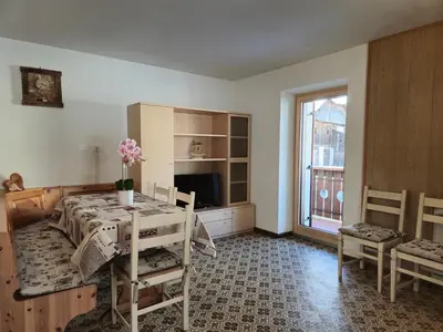 a dining room with a table and a window at La Casa del Mulino in Pozza di Fassa