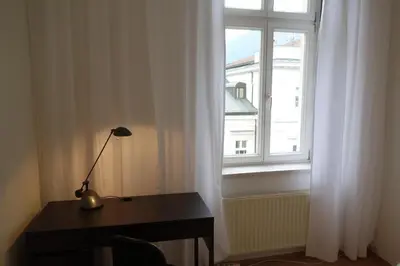 a desk with a lamp in front of a window at Hager Apartment in Merano