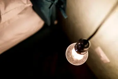 a light bulb hanging from a door with a person at Stay COOPER l Goethe Suite in Bolzano