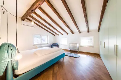 a bedroom with a large bed in a room with wooden floors at Stay COOPER l Goethe Suite in Bolzano