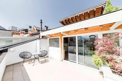 a balcony with two chairs and a table on a house at Stay COOPER l Goethe Suite in Bolzano