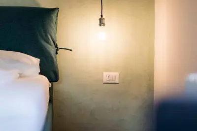 a bedroom with a bed and a light switch at Stay COOPER l Goethe Suite in Bolzano