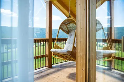 a hammock on a porch with a view of the mountains at Mair am Graben Farm * Chalets in Terento